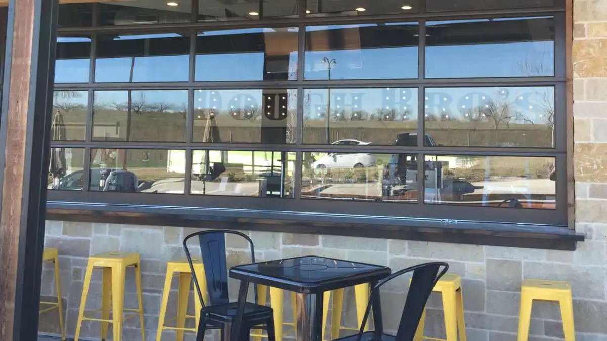 Commercial full view glass garage door on restaurant storefront
